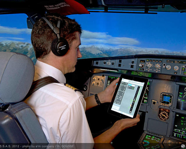 Pilot in the cockpit using flysmart app on tablet Pilot in the cockpit using flysmart app on tablet